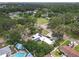 Wide aerial view showing a home with solar panels and a circular driveway amidst a lush, green neighborhood at 2704 Dorene Dr, Plant City, FL 33563