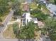 Aerial view of a house with solar panels and a circular driveway amidst lush trees at 2704 Dorene Dr, Plant City, FL 33563