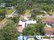 Aerial neighborhood view featuring a home with solar panels and circular driveway set among mature trees at 2704 Dorene Dr, Plant City, FL 33563