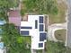 Top-down aerial view of a white roof with solar panels, surrounded by lush trees at 2704 Dorene Dr, Plant City, FL 33563