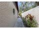 Side of the home featuring a sidewalk, landscaping, and small round window at 2704 Dorene Dr, Plant City, FL 33563