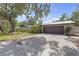Detached two-car garage with concrete driveway and mature landscaping at 2704 Dorene Dr, Plant City, FL 33563