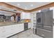 Kitchen showcasing stainless steel refrigerator, white cabinets, granite counters, and tile flooring at 2704 Dorene Dr, Plant City, FL 33563