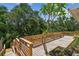 Wooden deck with lattice railings, featuring a small tree and colorful flower beds at 2742 Wilson Ct, Palm Harbor, FL 34684