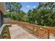 Multi-tiered wooden deck with lattice railing, surrounded by mature trees and flower beds at 2742 Wilson Ct, Palm Harbor, FL 34684