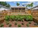Wooden deck surrounded by flower beds and manicured landscaping, creating a serene backyard setting at 2742 Wilson Ct, Palm Harbor, FL 34684