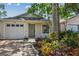 Charming single-story home featuring lush landscaping, a one-car garage, and a welcoming front entrance at 2742 Wilson Ct, Palm Harbor, FL 34684