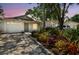 Charming single-story home featuring lush landscaping, a one-car garage, and a welcoming front entrance at 2742 Wilson Ct, Palm Harbor, FL 34684