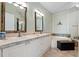 Bathroom features double vanity, tub, large framed mirrors, and neutral tile flooring at 2773 Via Cipriani # 1310A, Clearwater, FL 33764