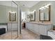 Bathroom with dual sinks, large mirrors, a tub, and a glimpse of the bedroom at 2773 Via Cipriani # 1310A, Clearwater, FL 33764