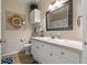 Bright bathroom featuring a white vanity with tile countertops, decorative mirror, and patterned shower curtain at 2773 Via Cipriani # 1310A, Clearwater, FL 33764