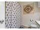 Bathroom featuring a patterned shower curtain, tile flooring, and a decorative tile piece on the wall at 2773 Via Cipriani # 1310A, Clearwater, FL 33764