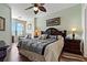 Comfortable bedroom with a ceiling fan, a large bed, and a seating area by the window at 2773 Via Cipriani # 1310A, Clearwater, FL 33764