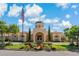 Stately entrance to Villa d'Este with manicured landscaping, palm trees, and elegant architecture at 2773 Via Cipriani # 1310A, Clearwater, FL 33764