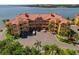 Beautiful waterfront condo building featuring a red tile roof and lush landscaping at 2773 Via Cipriani # 1310A, Clearwater, FL 33764