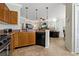 Well-lit kitchen with granite countertops, wood cabinets, and an open view into the living area at 2773 Via Cipriani # 1310A, Clearwater, FL 33764