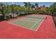 Outdoor tennis court with lush landscaping and palm trees in a well-maintained community at 2773 Via Cipriani # 1310A, Clearwater, FL 33764
