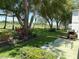 Well-maintained backyard with mature trees, landscaping, and a cozy patio area at 303 Meadow Ln, Oldsmar, FL 34677