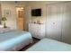 Comfortable bedroom with two twin beds, dresser, and neutral decor at 303 Meadow Ln, Oldsmar, FL 34677