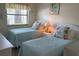 Cozy bedroom with two twin beds, a window, and stylish decor at 303 Meadow Ln, Oldsmar, FL 34677