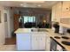 Open kitchen with white cabinets, modern appliances, and views into the living room at 303 Meadow Ln, Oldsmar, FL 34677