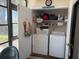 Convenient laundry area with washer, dryer, and storage shelving at 303 Meadow Ln, Oldsmar, FL 34677