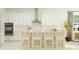 An eat-in kitchen with modern white cabinets, stainless steel appliances, and stylish bar stool seating at 31483 Cardinal Yard Dr, San Antonio, FL 33576