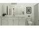 Bright bathroom featuring a single sink vanity with white cabinets, framed art, and a shower with decorative curtain at 31561 Cardinal Yard Dr, San Antonio, FL 33576