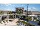 An outside aerial view of community clubhouse featuring white lounge chairs, lush landscaping and modern design at 31561 Cardinal Yard Dr, San Antonio, FL 33576