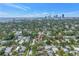 Aerial view of the property nestled among mature trees with cityscape in the distance at 356 20Th Ne Ave, St Petersburg, FL 33704