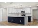 Open kitchen featuring a large island with dark navy accents, modern pendant lighting, and stainless steel appliances at 3709 Danny Bryan Blvd, Tampa, FL 33619