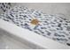 Tiled shower floor with hexagon tiles and a gold drain, showcasing modern design and attention to detail at 3709 Danny Bryan Blvd, Tampa, FL 33619