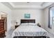 Comfortable bedroom featuring a tray ceiling, neutral tones, and an ensuite bathroom at 3719 Stormy Thistle Pl, Plant City, FL 33565