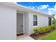 Inviting front entrance with a gray door, a welcome mat, a window and well-maintained landscaping at 3719 Stormy Thistle Pl, Plant City, FL 33565