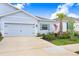 Charming single-story home with a well-manicured lawn, a two car garage, and a beautiful palm tree at 3719 Stormy Thistle Pl, Plant City, FL 33565