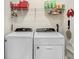 Functional laundry room with a side-by-side washer and dryer and storage shelves at 3719 Stormy Thistle Pl, Plant City, FL 33565