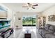 Bright living room featuring tile floors, a ceiling fan, comfortable seating, and sliding glass doors to the lanai at 3719 Stormy Thistle Pl, Plant City, FL 33565