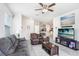 Cozy living room features tile floors, a ceiling fan, comfortable seating, and a view into the kitchen at 3719 Stormy Thistle Pl, Plant City, FL 33565