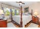Serene bedroom features a four-poster bed, side tables, and a window with blue and white valances at 3904 Bridlecrest Ln, Bradenton, FL 34209