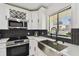 Modern kitchen with stainless steel appliances, white cabinets, wine rack and black backsplash at 4017 Cedar Limb Ct, Tampa, FL 33614