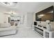 Bright living room with modern white tile floors, a large TV, and an open layout leading to the kitchen at 4017 Cedar Limb Ct, Tampa, FL 33614