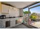 Enclosed outdoor kitchen featuring stone accents, white subway tile backsplash, and an open view to the backyard at 4017 Cedar Limb Ct, Tampa, FL 33614