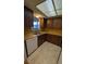 Galley kitchen featuring a stainless steel sink, wood cabinets, laminate countertops, and tile flooring at 4021 19Th N St, St Petersburg, FL 33714