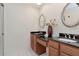 Bathroom featuring dual sinks with granite countertops, wood cabinets, and tile flooring at 4234 Brentwood Park Cir, Tampa, FL 33624