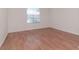 Bedroom with wood-look floors, base trim, and a bright window at 4234 Brentwood Park Cir, Tampa, FL 33624