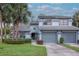 Inviting two-story home with a well-manicured lawn, lush landscaping, and an attached two-car garage at 4234 Brentwood Park Cir, Tampa, FL 33624
