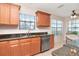 Well-lit kitchen featuring stainless steel appliances, granite countertops and natural wood cabinetry at 4234 Brentwood Park Cir, Tampa, FL 33624