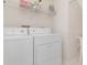 Bright laundry room features a washer, dryer, and wire shelving for storing supplies at 4234 Brentwood Park Cir, Tampa, FL 33624