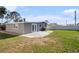 Spacious backyard featuring a concrete patio, lush lawn, and privacy fence, perfect for outdoor entertaining at 4521 W North St, Tampa, FL 33614