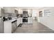 Open kitchen with stainless steel appliances, gray cabinets, and luxury vinyl plank flooring at 4521 W North St, Tampa, FL 33614